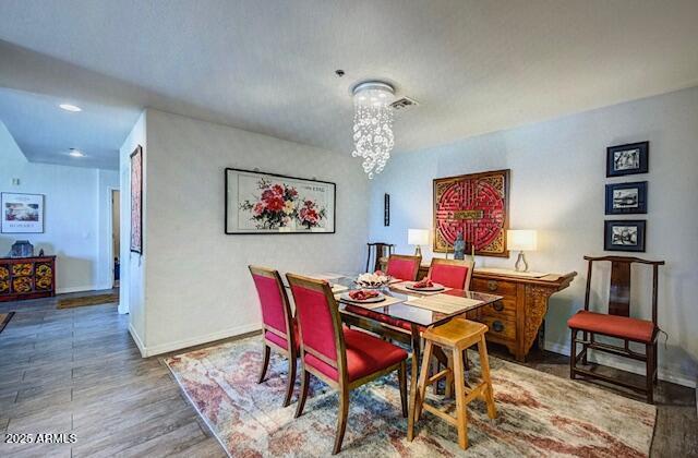 17 W Vernon Ave Unit 412, Phoenix, AZ 85003 - dining space featuring baseboards, wood finished floors, and an inviting chandelier