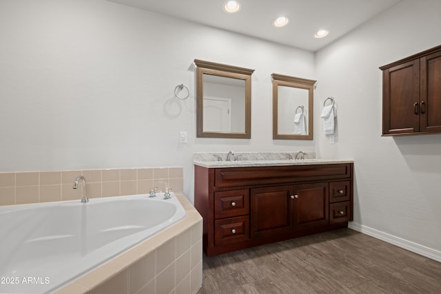 17 W Vernon Ave Unit 412, Phoenix, AZ 85003 - bathroom featuring a sink, double vanity, baseboards, wood finished floors, and a bath