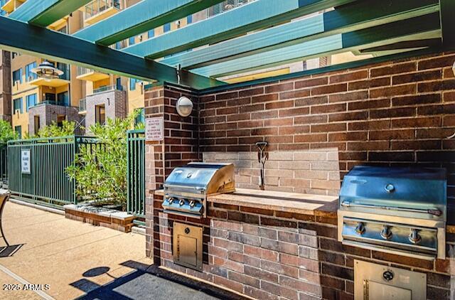 17 W Vernon Ave Unit 412, Phoenix, AZ 85003 - view of patio featuring fence, area for grilling, and an outdoor kitchen