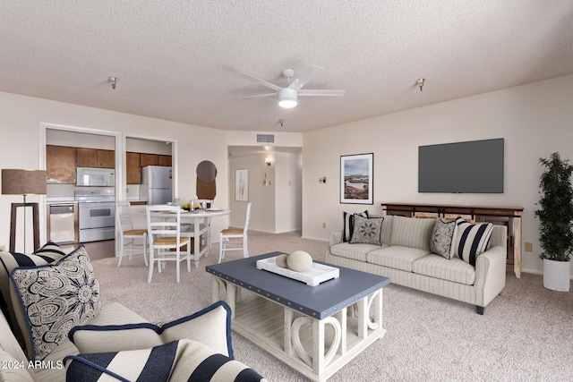 carpeted living room with a textured ceiling and ceiling fan