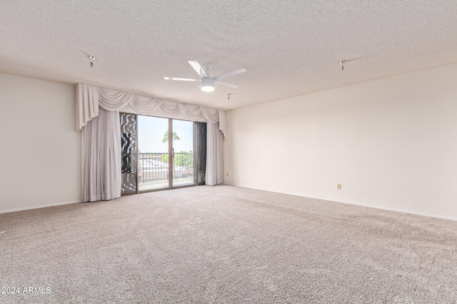 carpeted empty room with ceiling fan and a textured ceiling