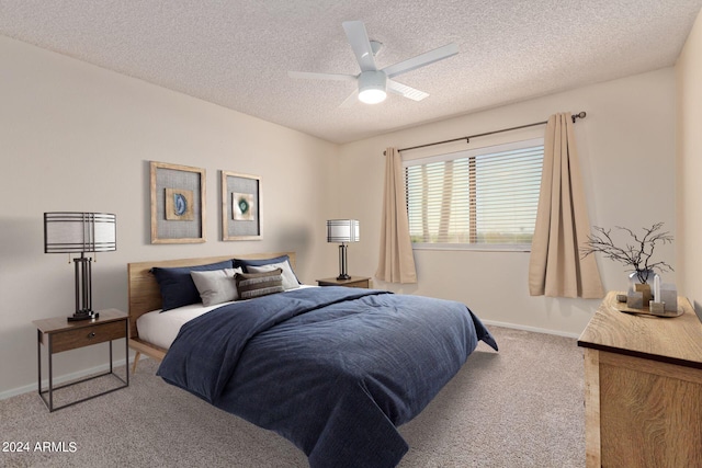 carpeted bedroom featuring ceiling fan and a textured ceiling