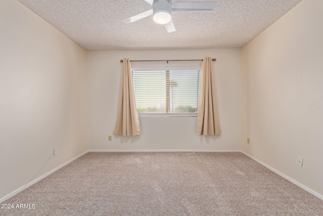 carpeted spare room featuring ceiling fan and a textured ceiling