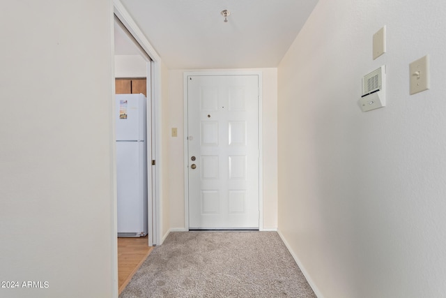 doorway to outside featuring light carpet