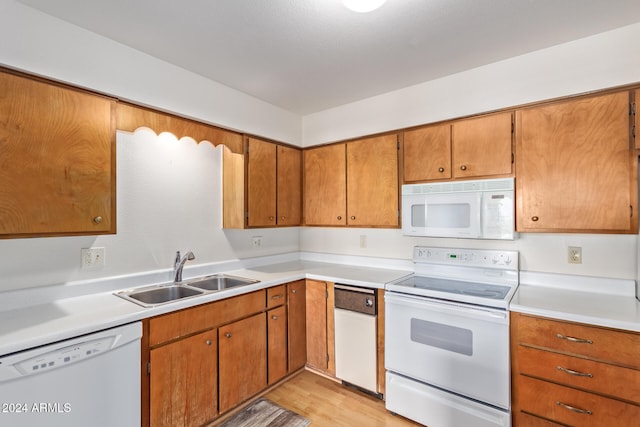 kitchen featuring light wood-type flooring, white appliances, and sink