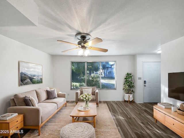 living room with ceiling fan, dark wood-type flooring, and a textured ceiling