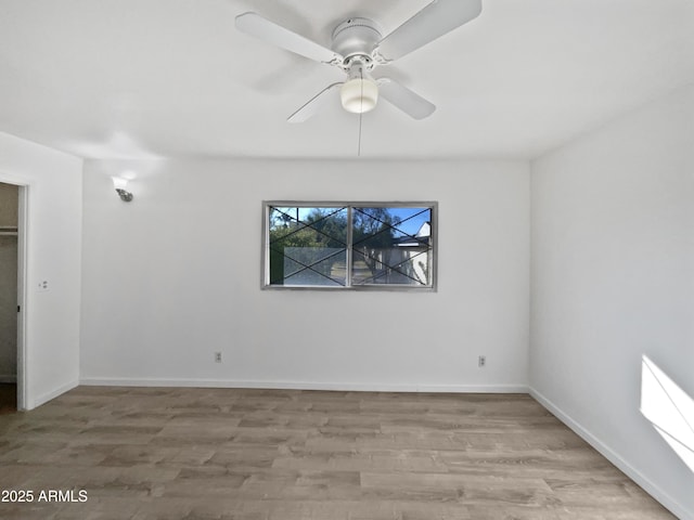 spare room with ceiling fan and light wood-type flooring