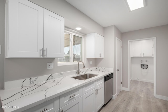 kitchen featuring sink, light stone counters, stainless steel dishwasher, white cabinets, and light wood-type flooring