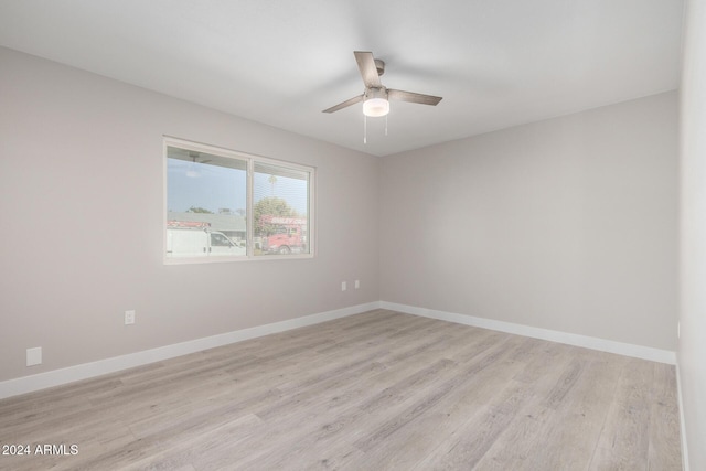 empty room with ceiling fan and light hardwood / wood-style flooring