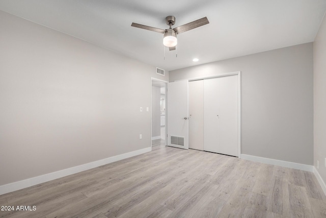 unfurnished bedroom featuring ceiling fan, a closet, and light wood-type flooring