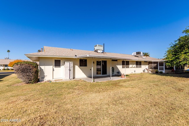 back of property featuring central AC, a patio area, and a lawn