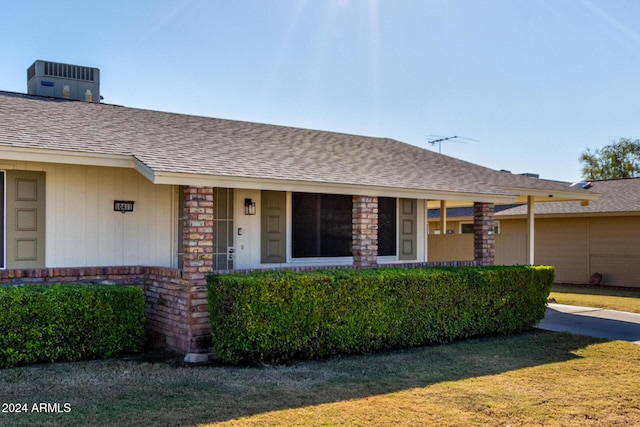 view of front of house featuring a front yard and central AC unit