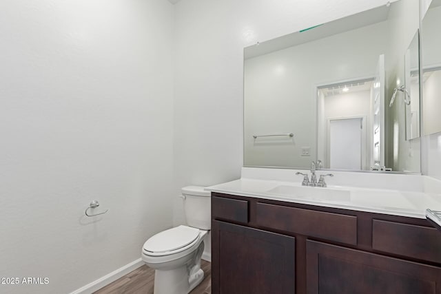 bathroom featuring hardwood / wood-style flooring, toilet, and vanity