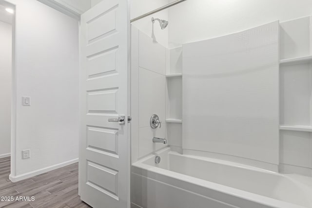 bathroom featuring wood-type flooring and shower / washtub combination