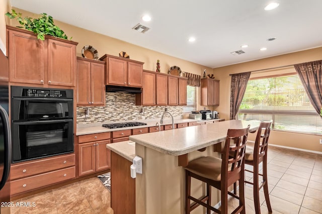 2413 W Kachina Trl, Phoenix, AZ 85041 - kitchen featuring decorative backsplash, a center island, a breakfast bar area, brown cabinets, and recessed lighting