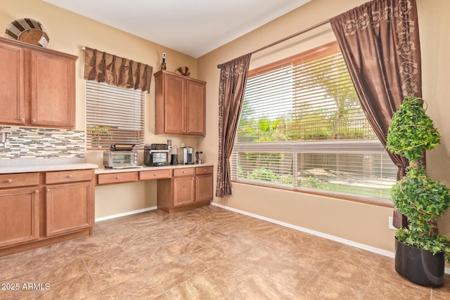 2413 W Kachina Trl, Phoenix, AZ 85041 - kitchen with light countertops, decorative backsplash, and brown cabinetry