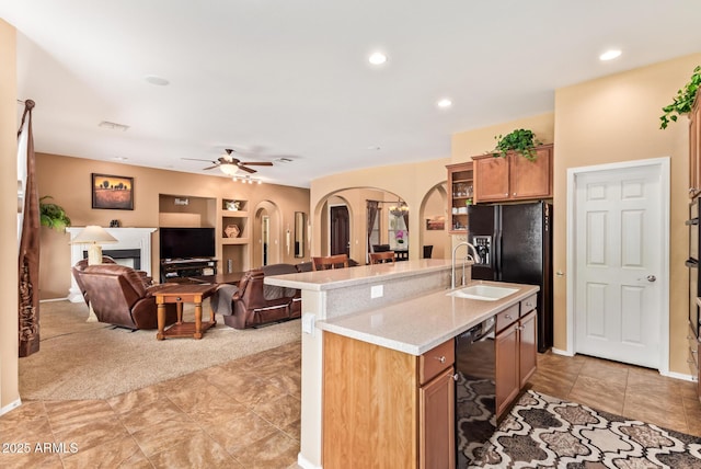 2413 W Kachina Trl, Phoenix, AZ 85041 - kitchen with arched walkways, ceiling fan, black appliances, built in features, and a center island with sink