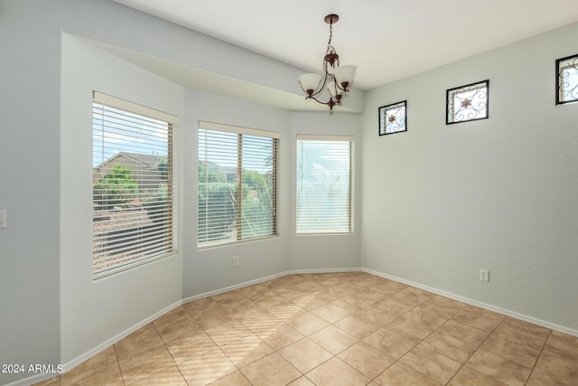 spare room featuring an inviting chandelier