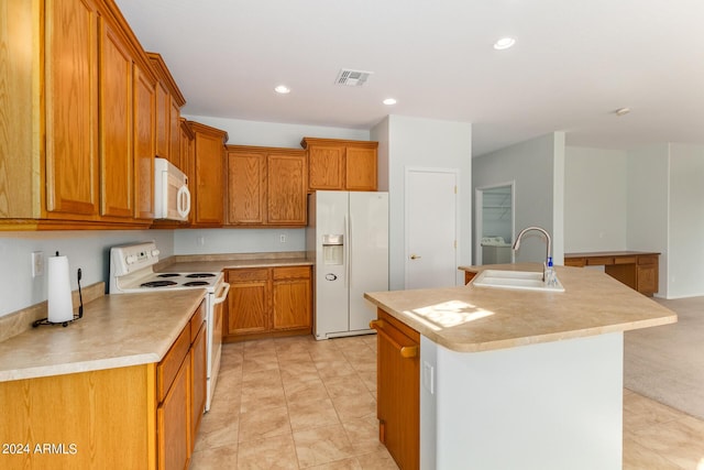 kitchen with an island with sink, sink, and white appliances