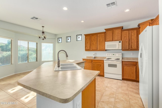 kitchen with light tile patterned flooring, decorative light fixtures, sink, a center island with sink, and white appliances