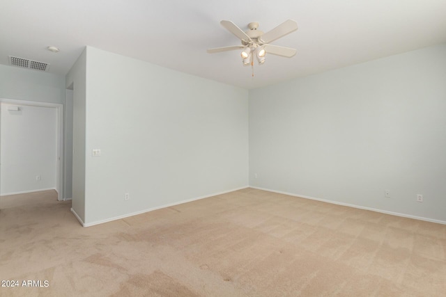 carpeted spare room featuring ceiling fan