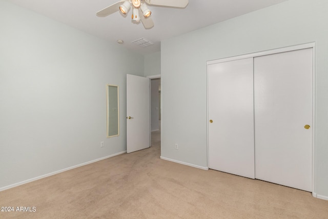 unfurnished bedroom featuring light carpet, a closet, and ceiling fan