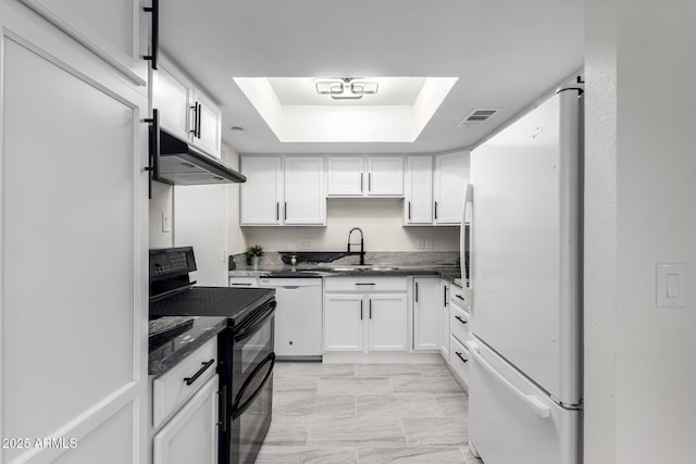 kitchen featuring sink, white appliances, white cabinets, and a raised ceiling