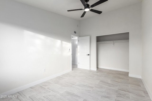 unfurnished bedroom with ceiling fan and a closet