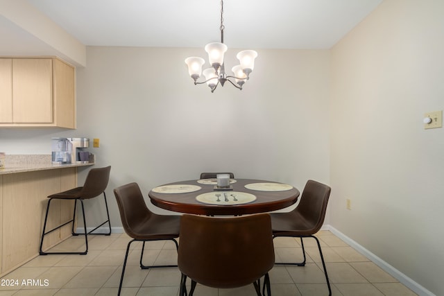 dining room with a chandelier and light tile floors