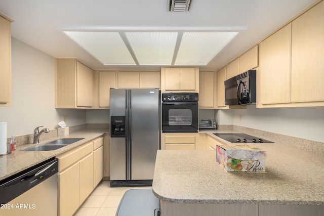 kitchen with light brown cabinetry, sink, light tile flooring, light stone countertops, and black appliances