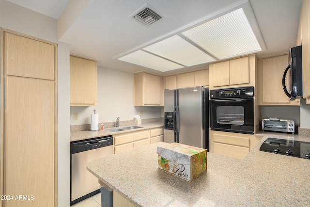 kitchen with light tile floors, light brown cabinetry, black appliances, and sink