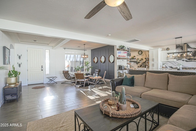 living room with wood-type flooring and ceiling fan with notable chandelier