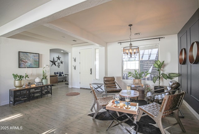 dining space featuring wood-type flooring and a notable chandelier