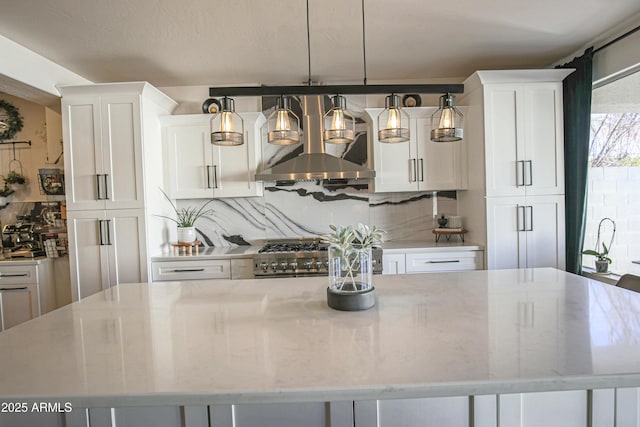 kitchen featuring light stone counters, pendant lighting, a large island, decorative backsplash, and white cabinets