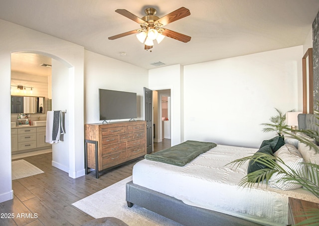 bedroom featuring ceiling fan, connected bathroom, and dark hardwood / wood-style floors