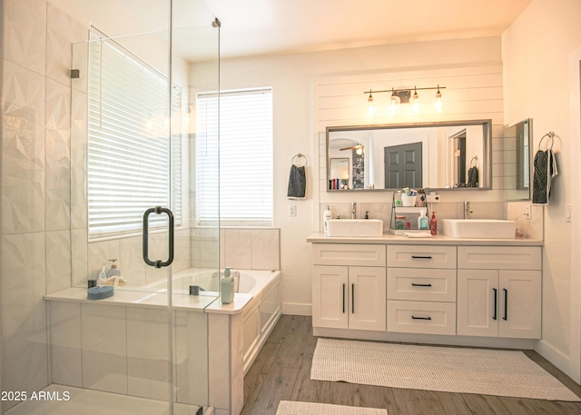 bathroom featuring hardwood / wood-style flooring, vanity, and separate shower and tub