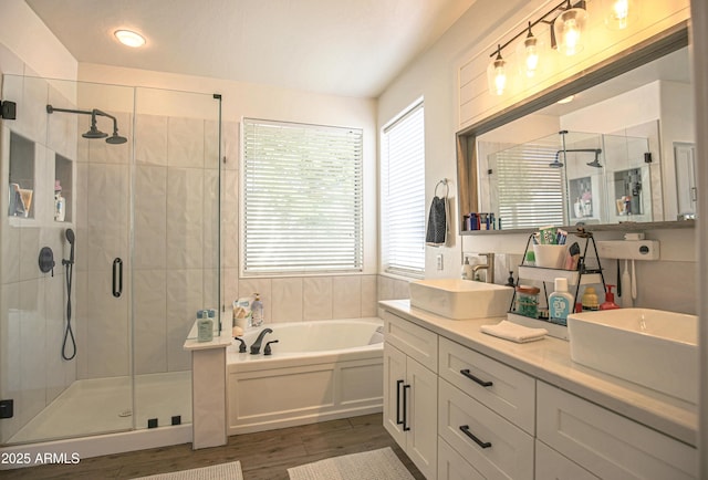 bathroom featuring vanity, hardwood / wood-style flooring, and plus walk in shower