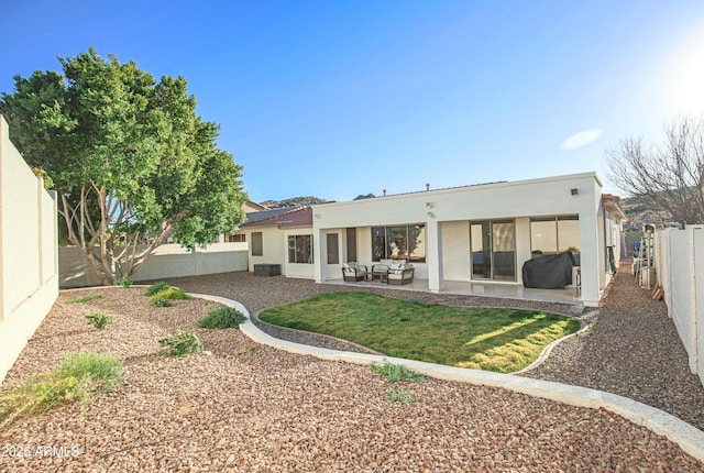 back of house featuring an outdoor living space and a patio area