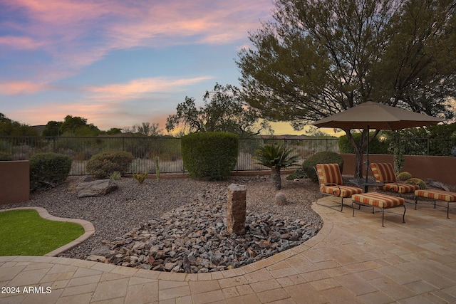 yard at dusk featuring a patio