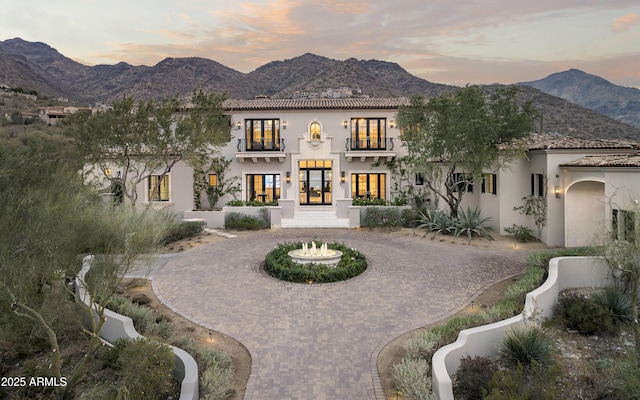 back house at dusk with french doors and a mountain view