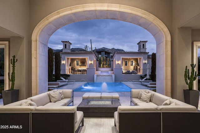 patio terrace at dusk with pool water feature and outdoor lounge area