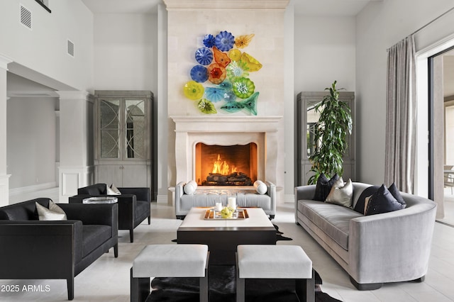 living area featuring ornate columns and a fireplace