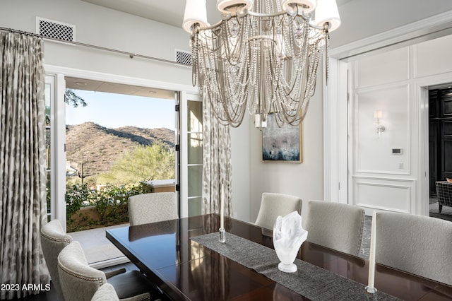 dining room featuring a mountain view and a notable chandelier