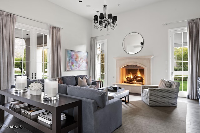 living room with dark hardwood / wood-style floors, a premium fireplace, and an inviting chandelier