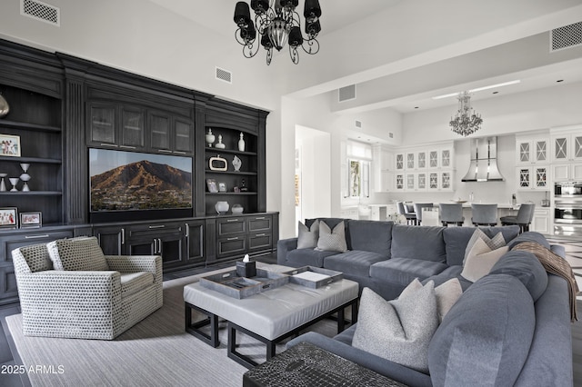 living room with built in shelves and a chandelier