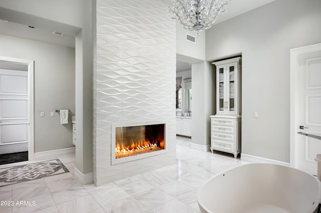 interior space featuring a tiled fireplace and a chandelier