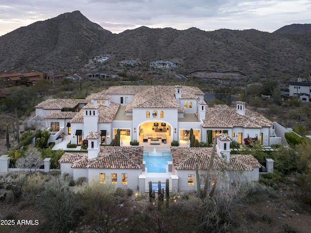 back house at dusk featuring a mountain view