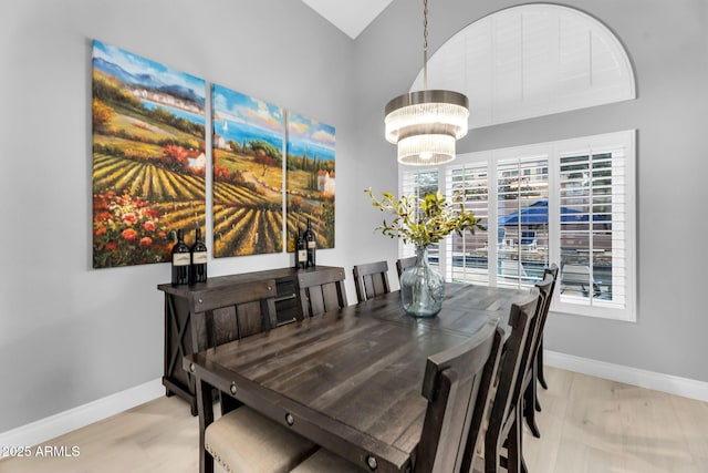 dining space featuring baseboards, a chandelier, and light wood-type flooring