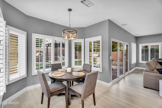 dining room with visible vents, baseboards, light wood-style floors, and a chandelier