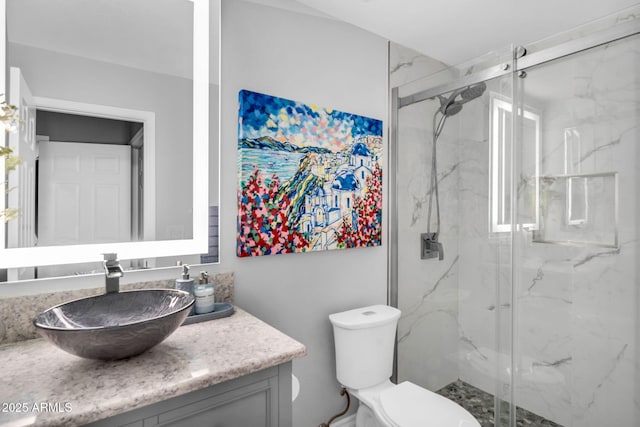 bathroom featuring vanity, toilet, and a marble finish shower